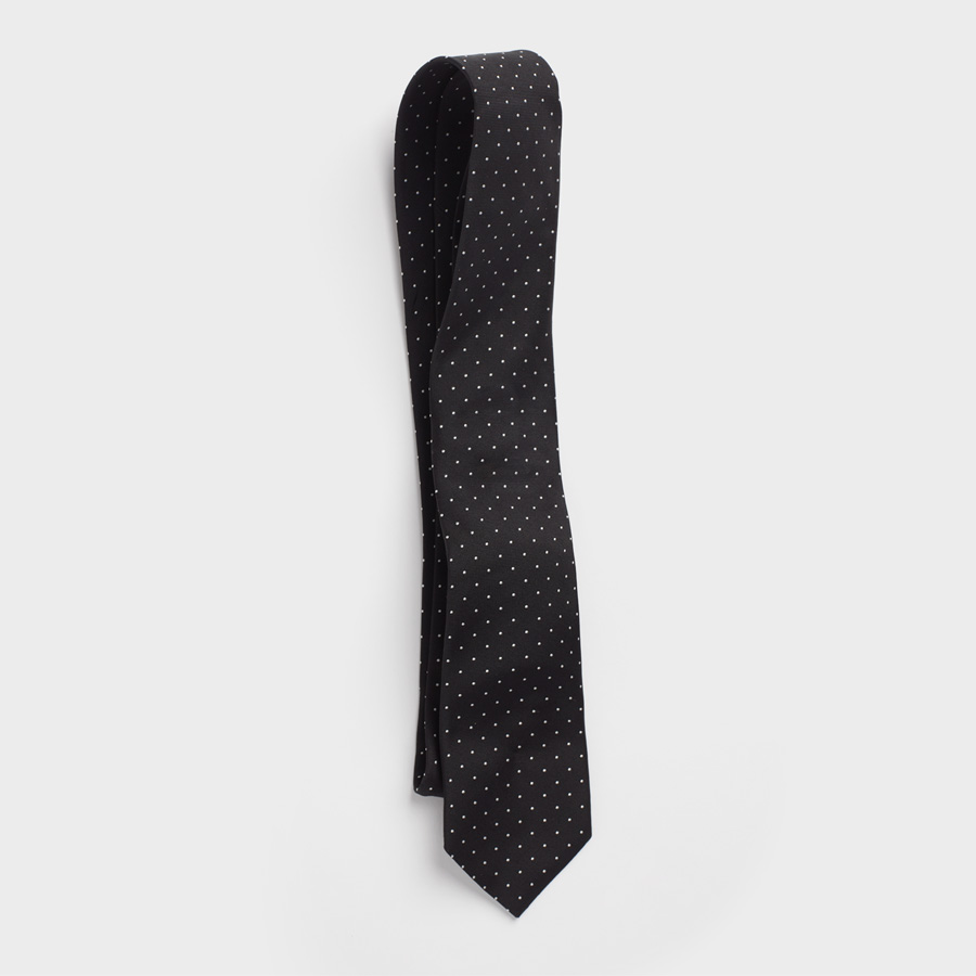 Black necktie by The Black Tux, made of 100% silk with white pindot motif.