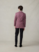 Person wearing a pink suit jacket and black pants, viewed from the back.