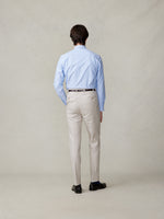 Man wearing a light blue shirt and beige pants, viewed from the back.