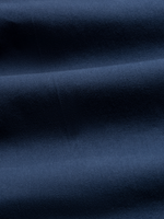 Close-up of navy chino fabric with folds, showing twill texture