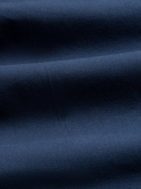 Close-up of navy chino fabric with folds, showing twill texture