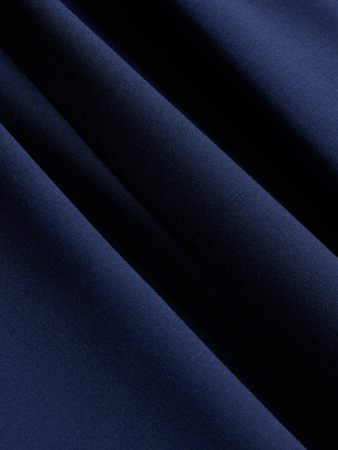 Close-up of cove blue suit fabric, a bright royal blue, draped in soft folds.
