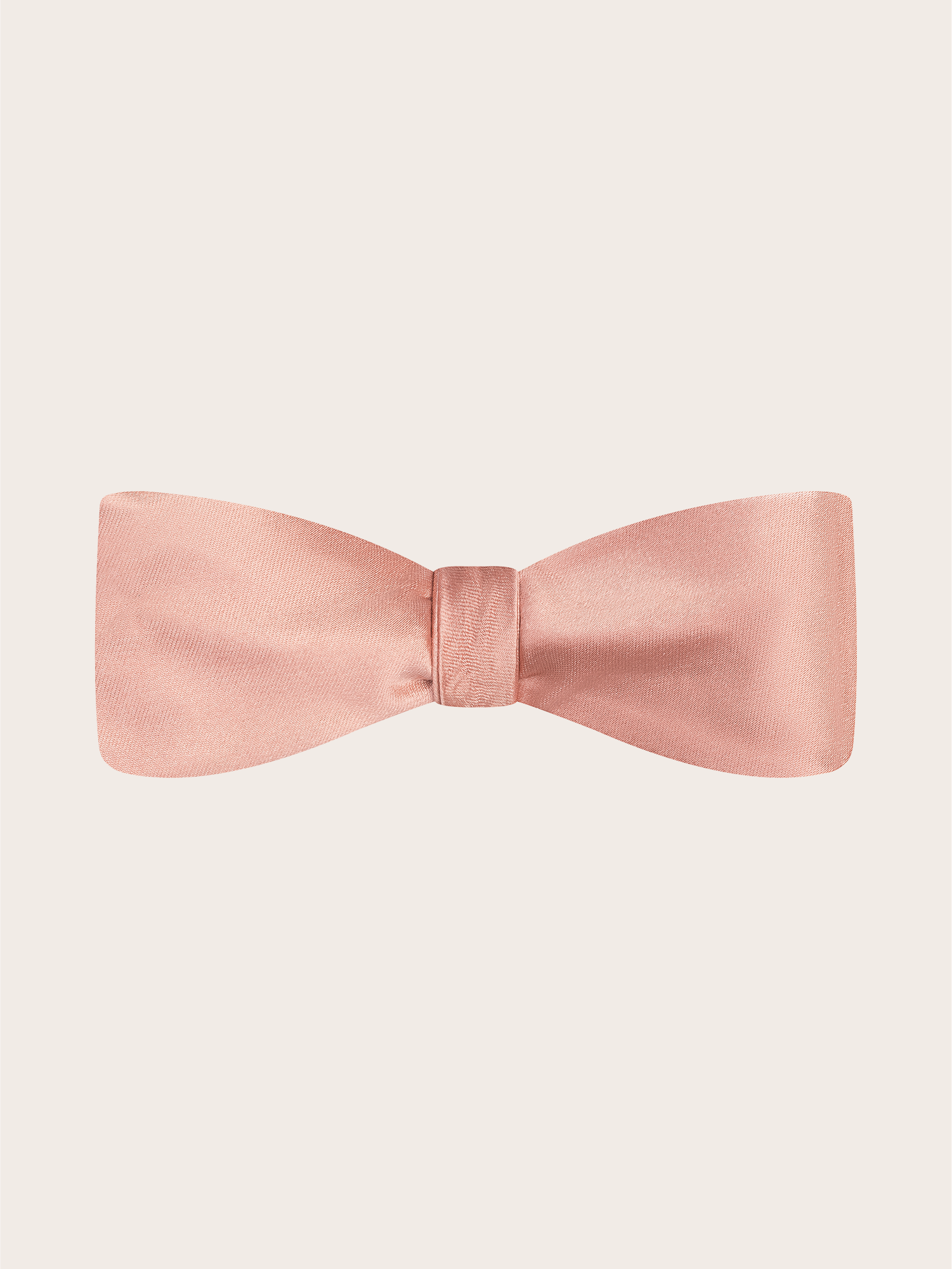 A pre-tied dusty rose satin bow tie against a light neutral background