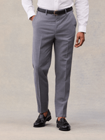 Cropped front view of slate grey suit trousers with pressed crease, black belt and black tassel loafers.