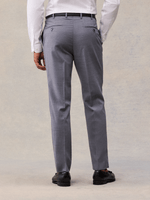 Cropped back view of slate grey suit trousers showing buttoned back welt pockets and black belt.