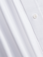 Close-up of a white shirt fabric with a button.