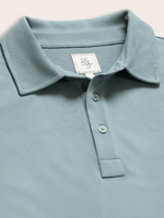 Close-up of light blue polo shirt collar, placket buttons, and brand label
