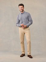 Smiling man in checked shirt and khaki chino trousers, full-length front view