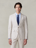 Man in a light beige suit with a blue shirt and dark tie.