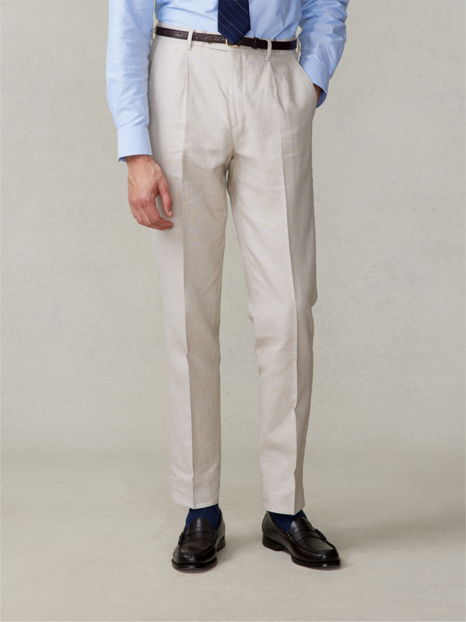 Man wearing light beige trousers, blue shirt, and dark shoes.