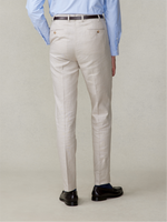 A man wearing light beige trousers and black shoes, viewed from the back.