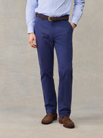Close-up of man in navy chino pants with brown belt, light blue striped shirt, front view