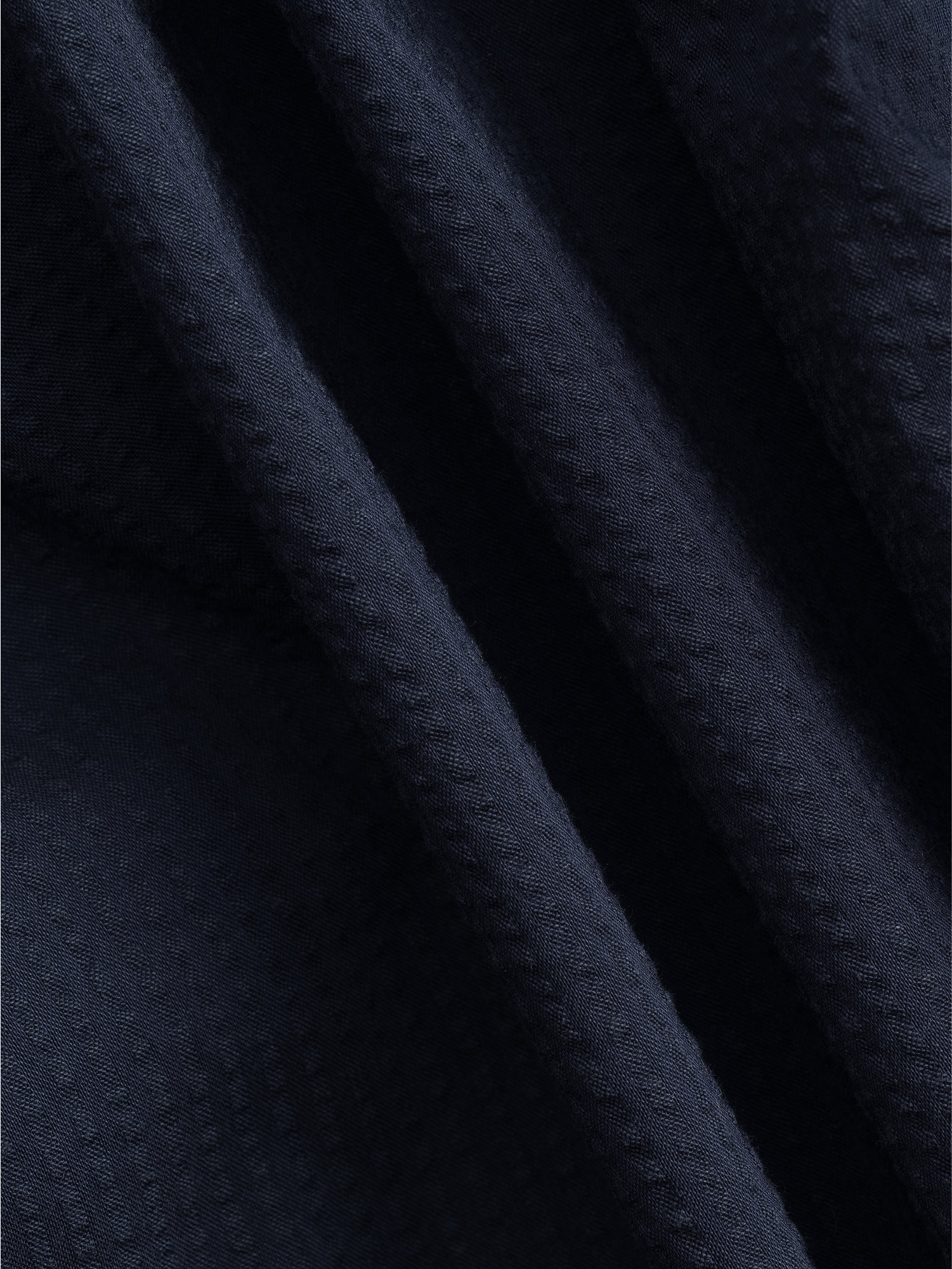 Close-up of dark navy fabric with a textured pattern.