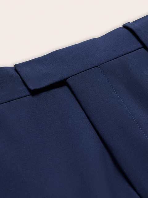 Close-up of cove blue suit pants waistband tab and front pocket.