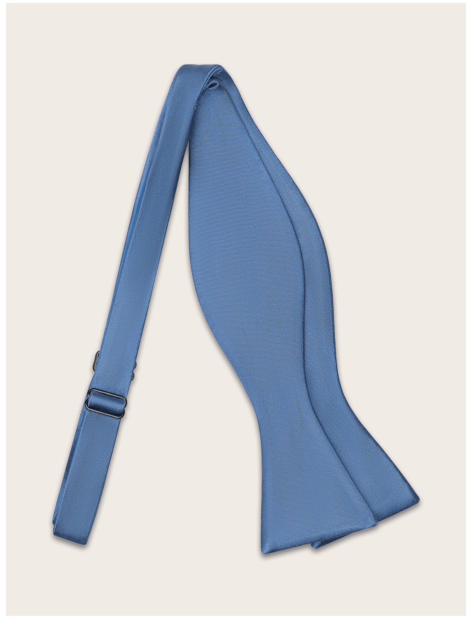 Steel blue bow tie untied against a light neutral background