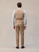 Back view of a camel suit vest with adjustable back strap, worn with matching trousers.