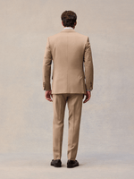 Back view of a model in a camel suit jacket and matching trousers.
