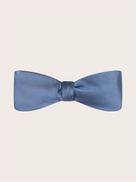 A pre-tied steel blue satin bow tie against a light neutral background