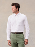 Man in white oxford shirt and olive green  trousers, front view, waist-up