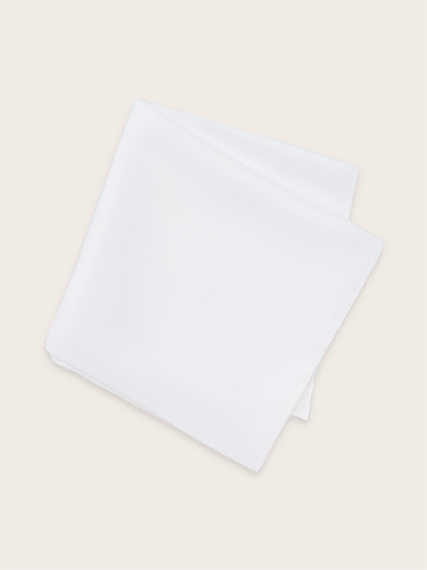 A white silk pocket square folded against a light background