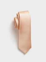Peach-colored tie with a ribbed texture, neatly rolled.