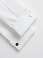 Two white shirt cuffs with buttons, one white and one black.