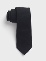 Rolled black tie on a white background.