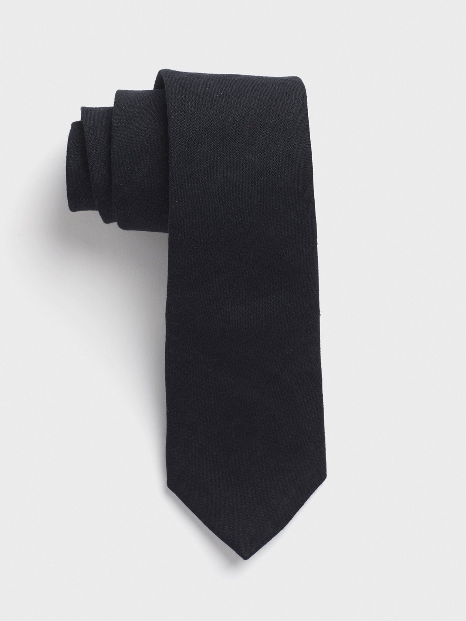 Rolled black tie on a white background.