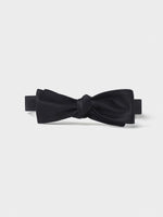Black bow tie with a smooth texture and a knot in the center.