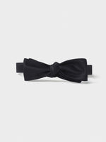 Black bow tie with a knot in the center on a white background.