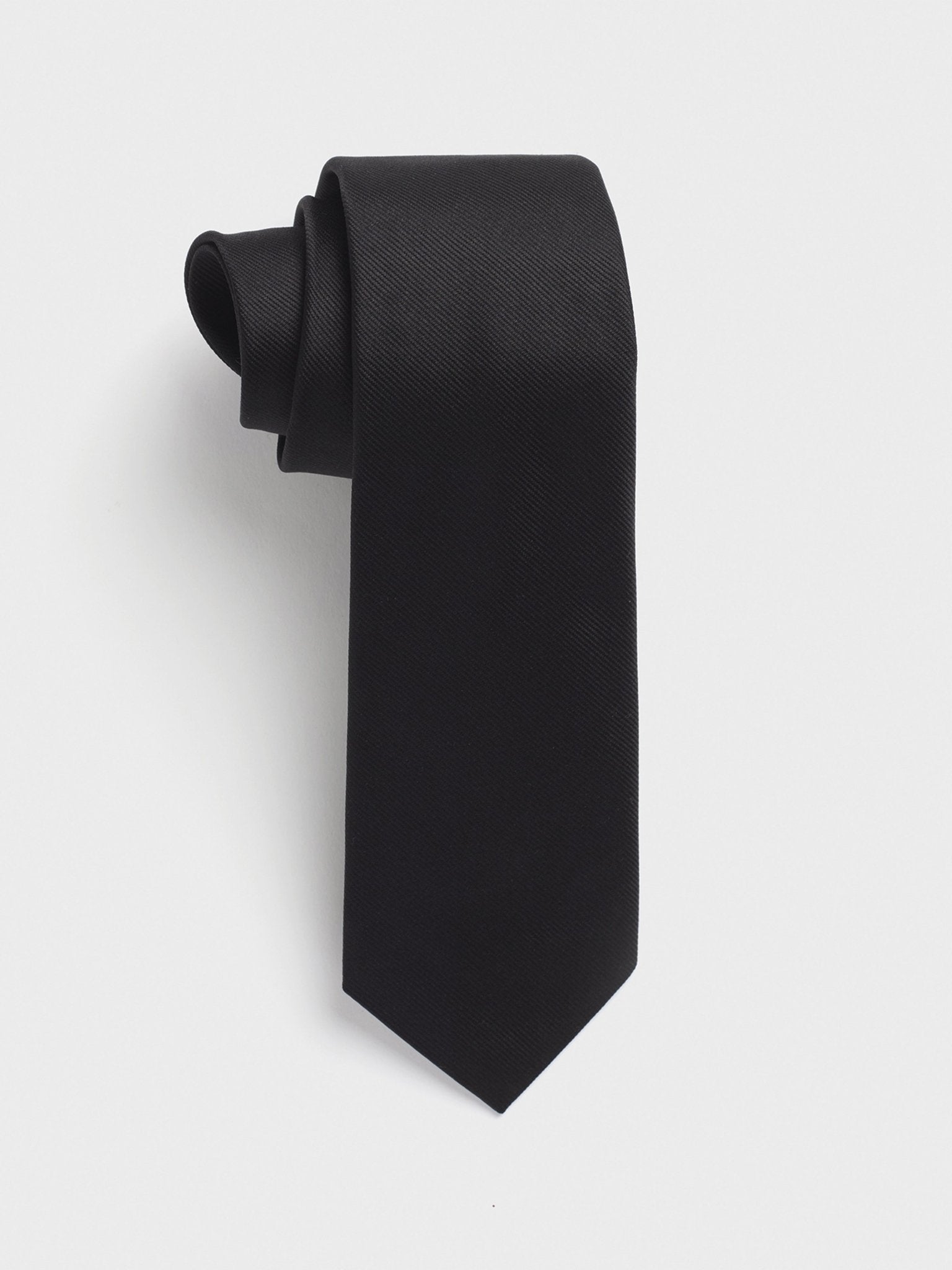 Rolled black tie with a textured pattern on a white background.