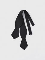Black bow tie with a textured finish laid flat on a white background.