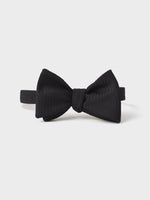 Black textured bow tie on a white background.