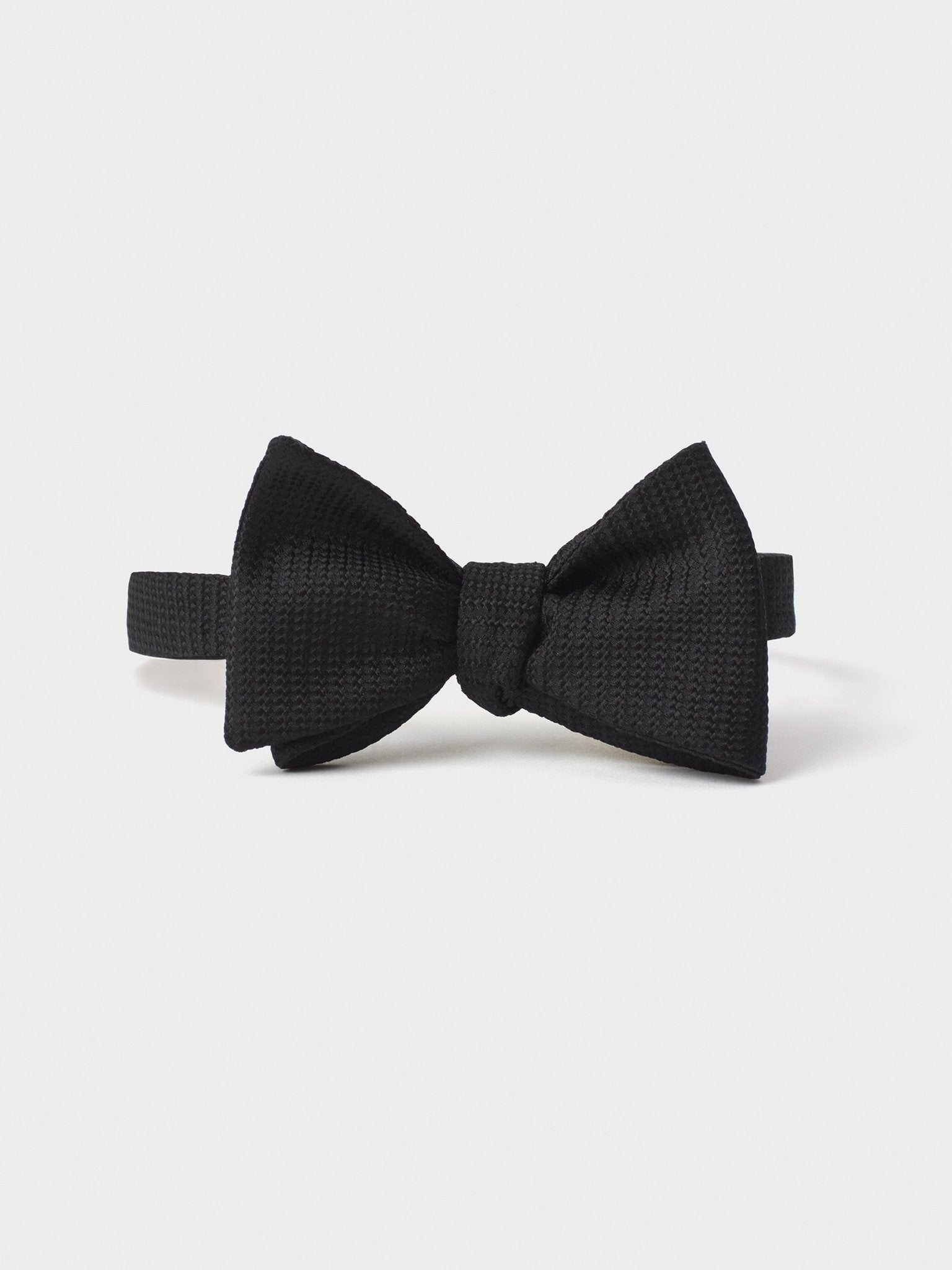 Black textured bow tie on a white background.
