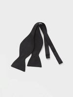 Black knitted bow tie with two ends and a central knot.