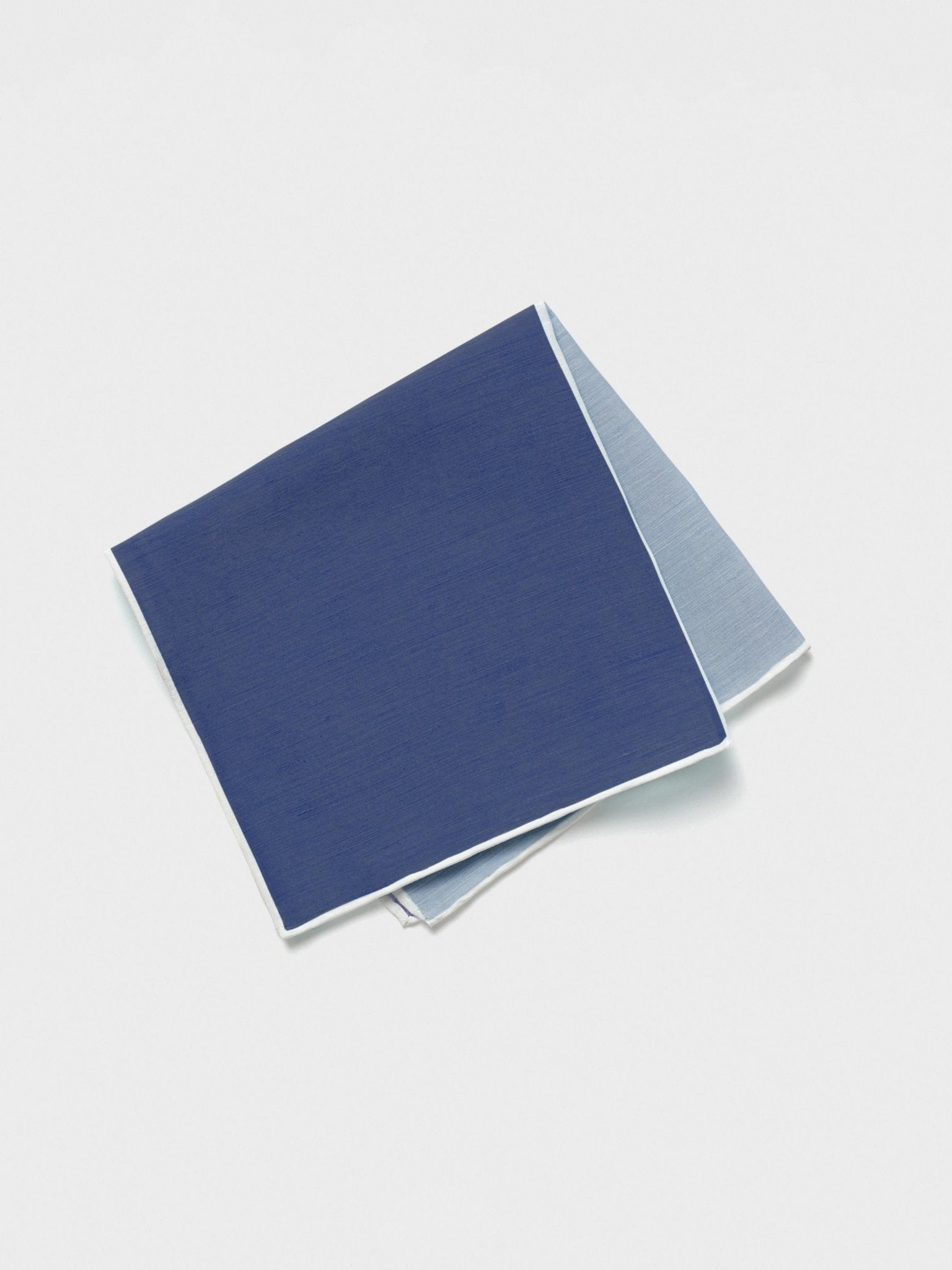 A folded pocket square in dark blue and light blue with a white border.