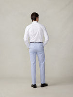 Man wearing a white shirt and striped pants, viewed from the back.