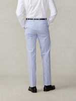 Man wearing striped blue pants and black shoes, viewed from the back.