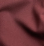 Close-up of textured burgundy fabric with folds and creases.