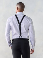 Man wearing a white shirt and black suspenders, viewed from the back.