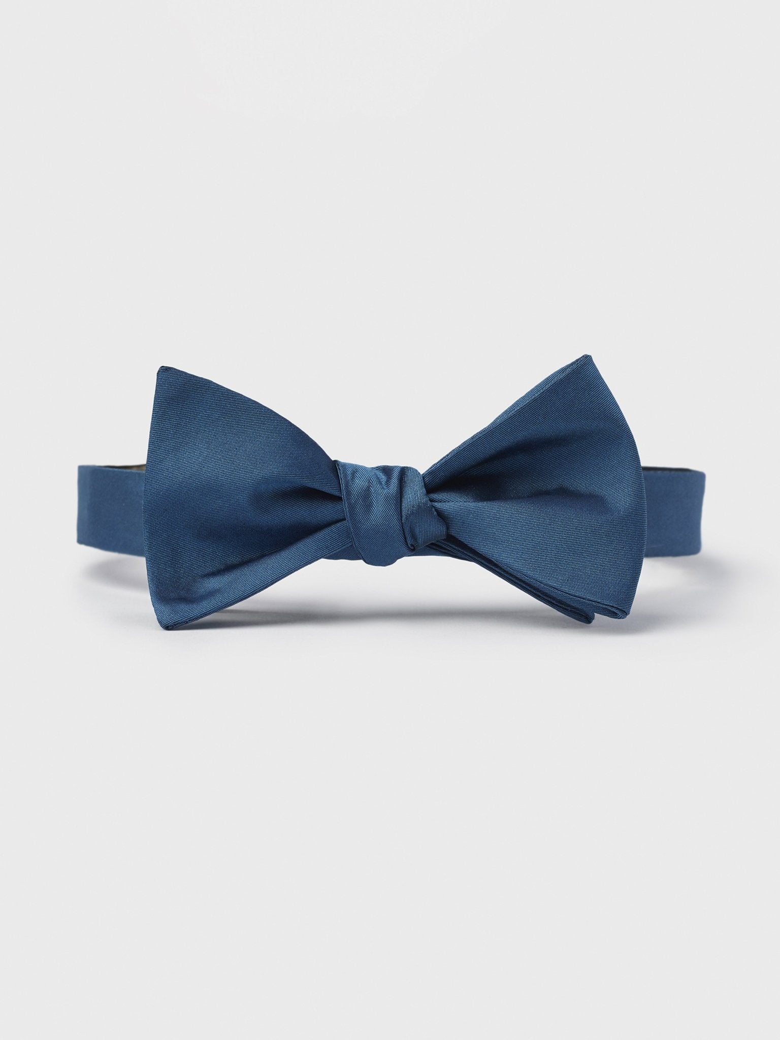 Navy blue bow tie on a white background.