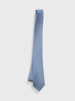 Light blue tie with a textured pattern, hanging against a white background.