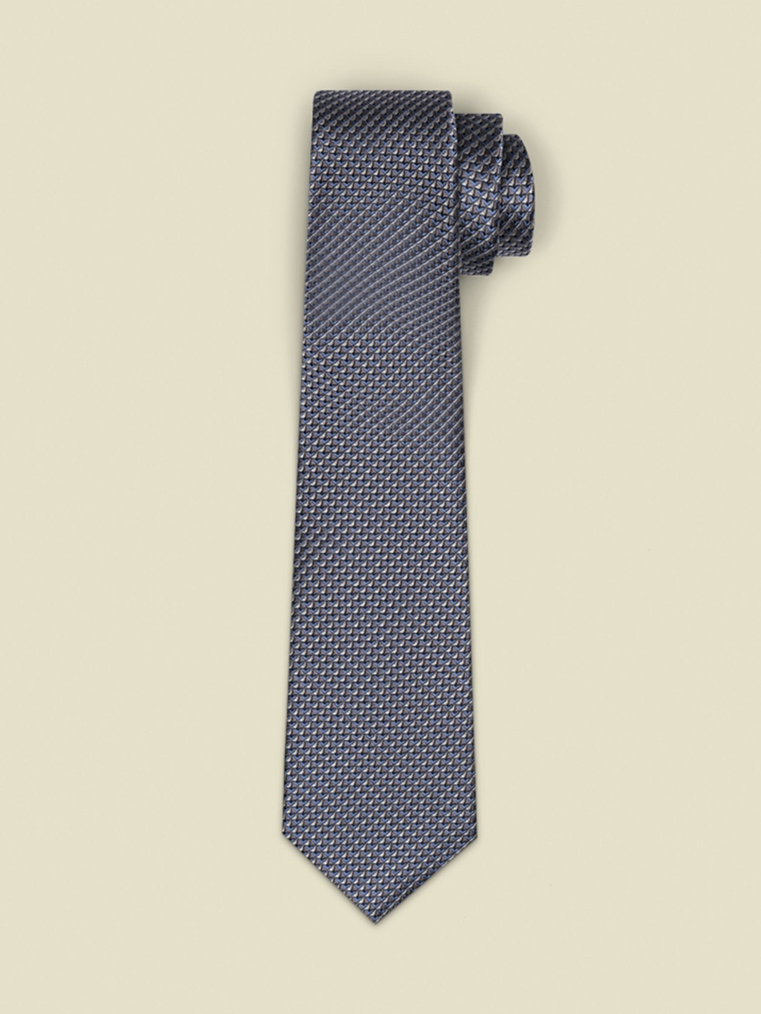 Navy tie with a textured pattern, rolled at the top, against a light background.