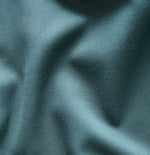 Close-up of teal fabric with a smooth texture and subtle sheen.