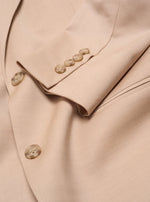 Close-up of a beige suit jacket with buttons on the cuff.