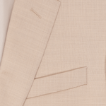 Close-up of a light beige suit jacket with a pocket and lapel.