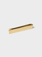 Gold tie clip on a white background.