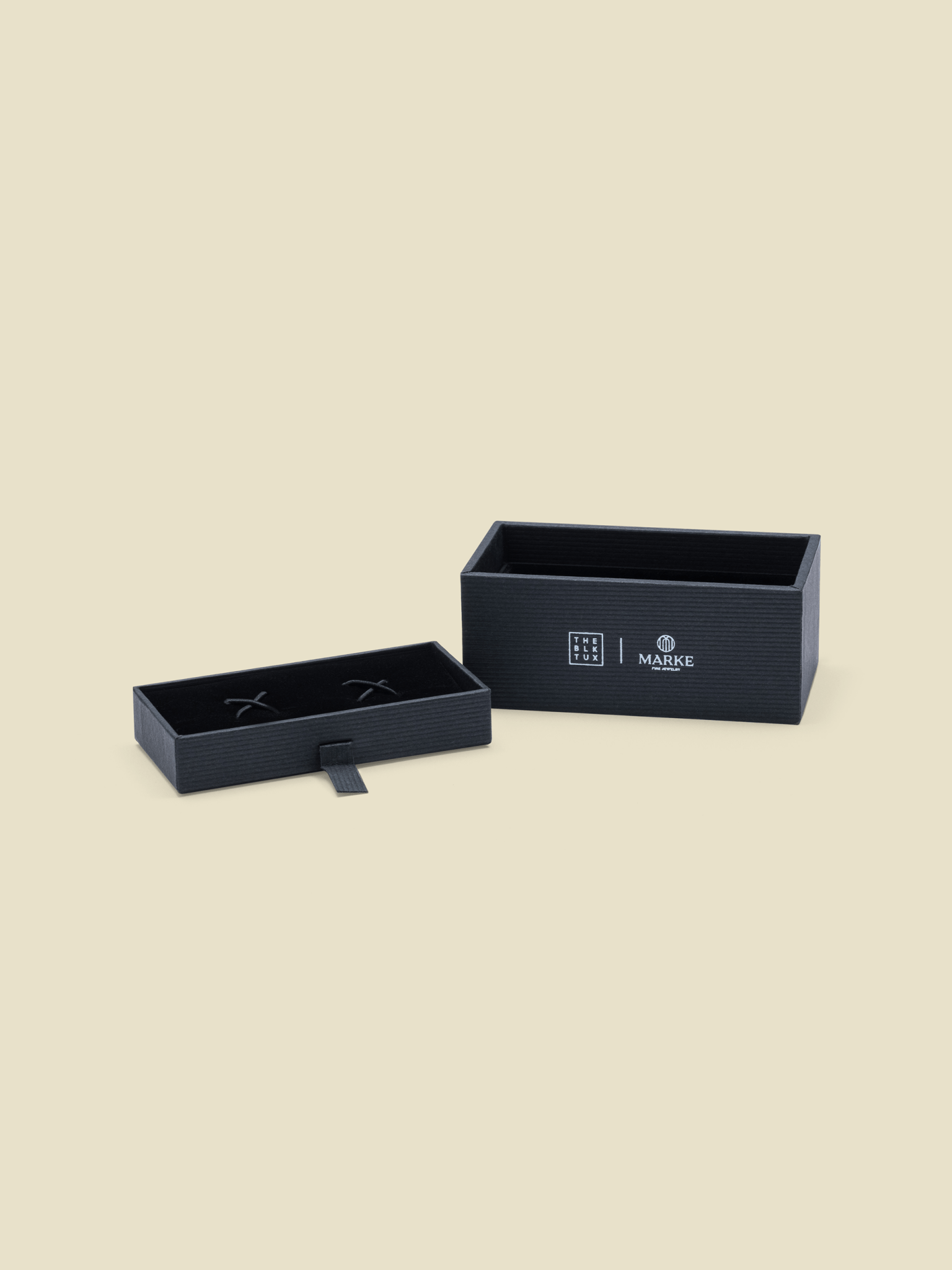 Open black box with a textured surface and a smaller inner box, both featuring logos.