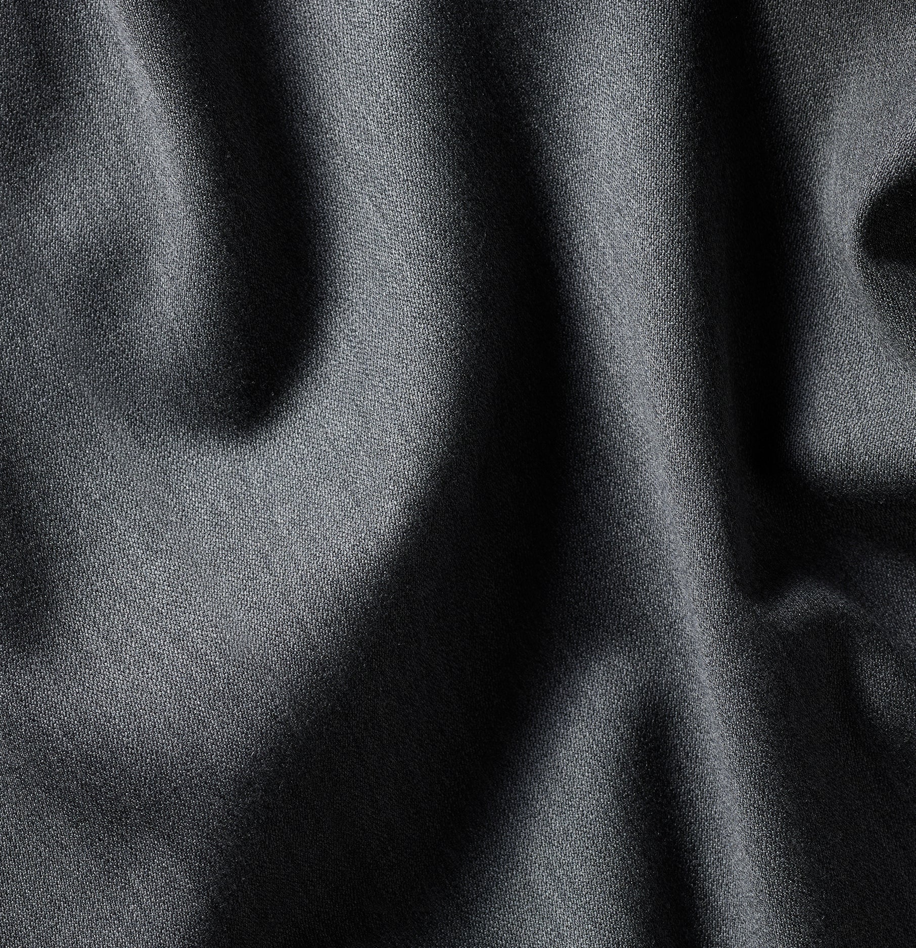 Close-up of dark fabric with soft texture and folds.