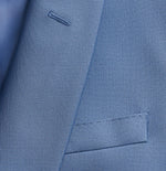 Close-up of a blue suit fabric with a pocket and stitching details.